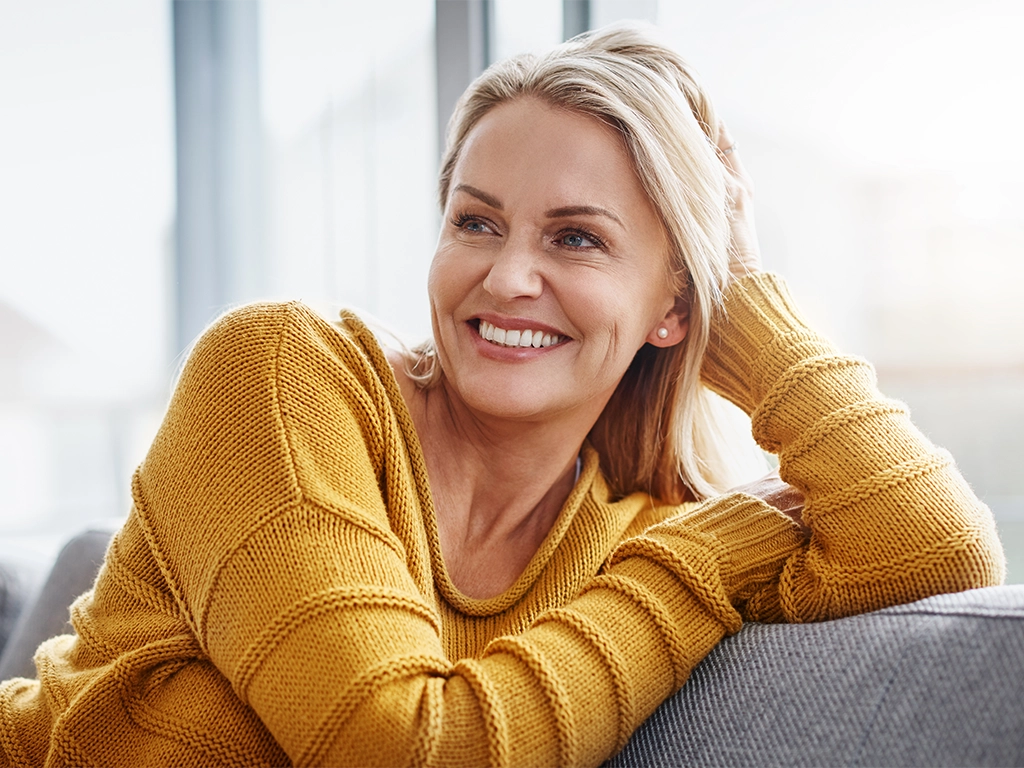 Attractive mature woman relaxing on a sofa and smiling comfortably